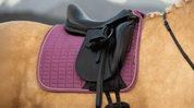 Close-up view of the mallow LeMieux Suede Dressage Square Pad on a palomino horse