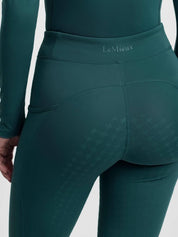 Close-up back view of a model wearing the jungle Lemieux Young Rider Orla Pull On Tight on a plain background