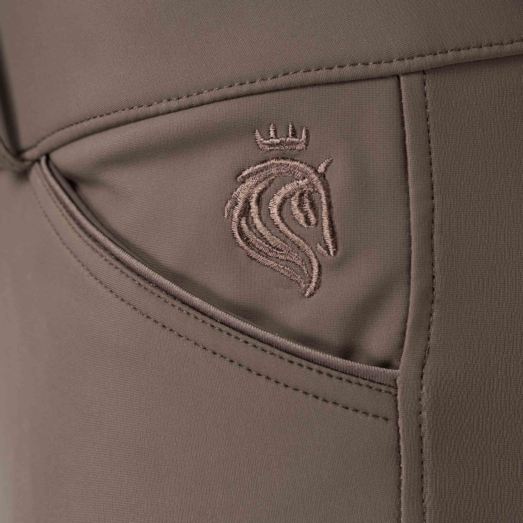 Closeup view of the Dark Brown Equinavia Maud Tech Full Seat Breeches showing an embroidered Equinavia logo near the pocket area