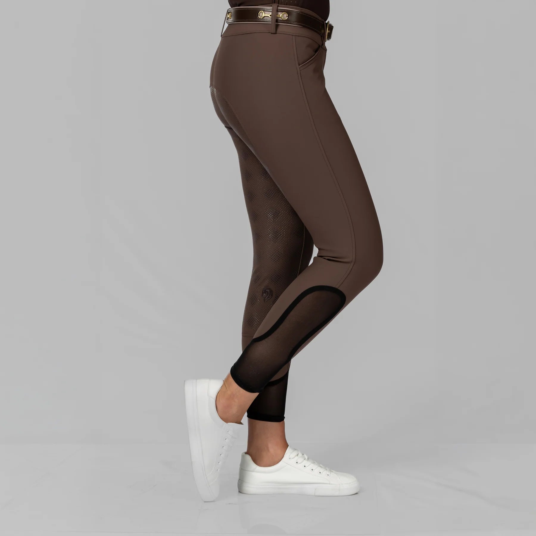 Side view of a model wearing the Dark Brown Equinavia Maud Tech Full Seat Breeches on a plain background