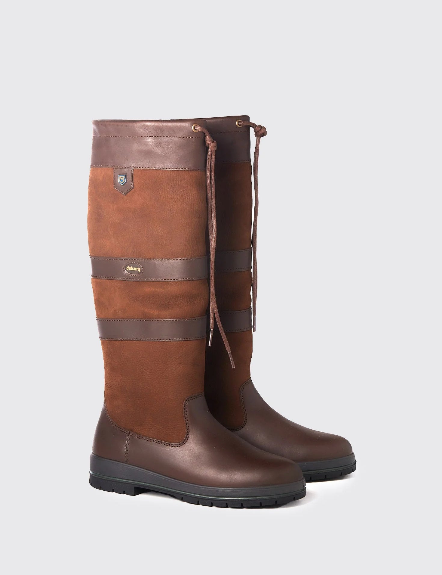 Pair of brown leather boots on a light gray background