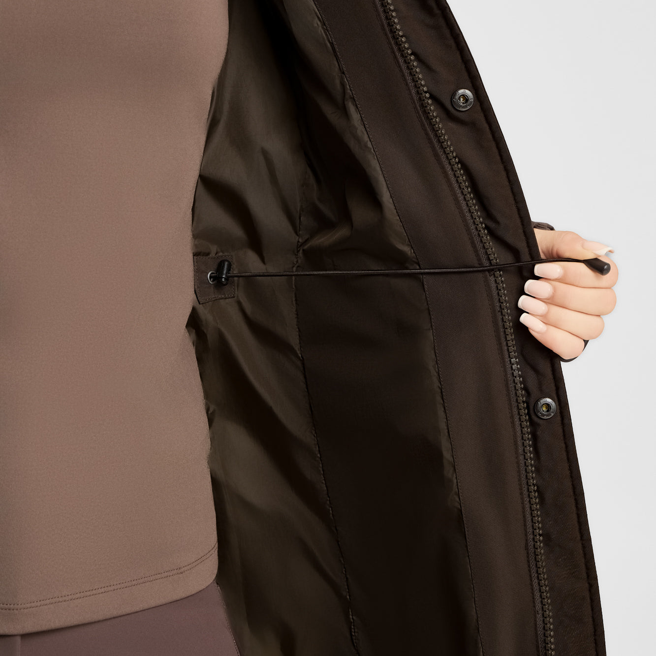 Close-up view of the adjustable waist on the Turkish Coffee B Vertigo Gem Waxed Padded Long Coat on a white background