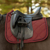 Side view of a horse wearing the Burgundy Equinavia Bergen Crystal Dressage Saddle Pad under a black saddle