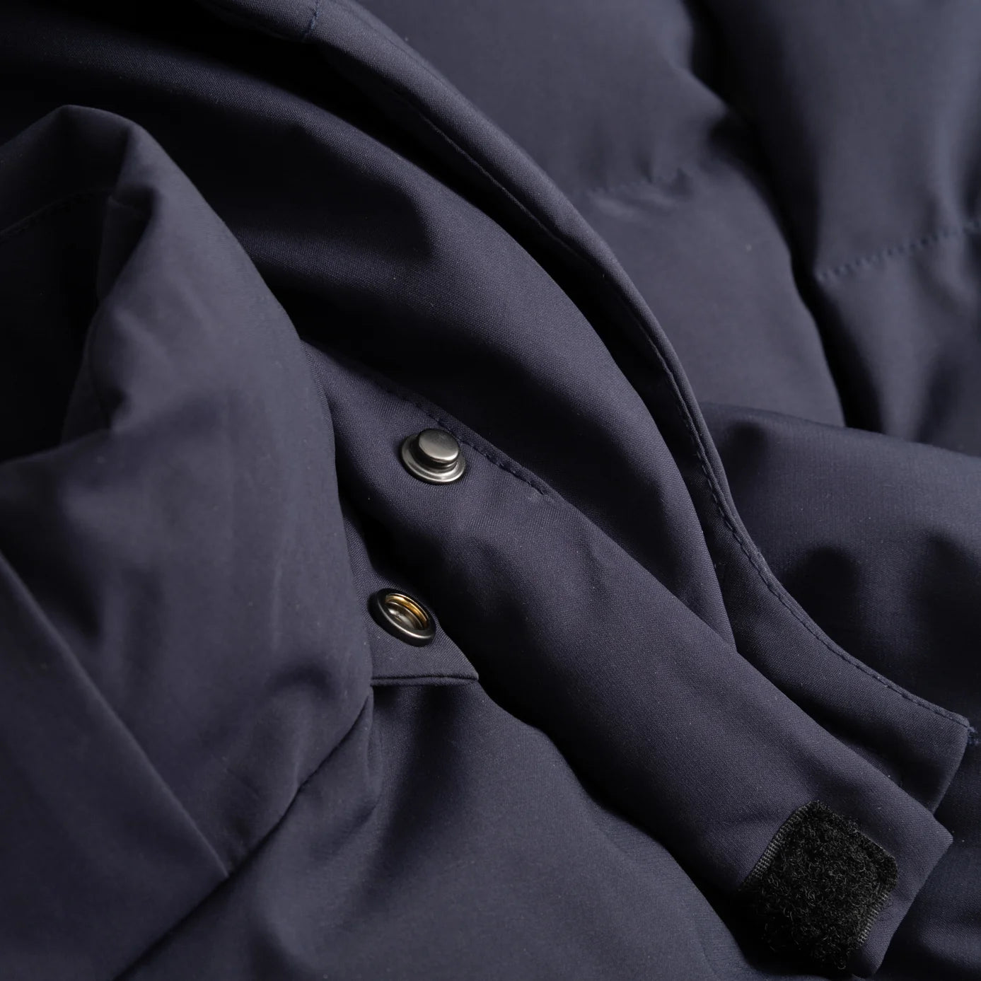 Closeup view of the Seaborne Navy Horze Paloma Kids Insulated Long Coat showing the button snaps