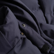 Closeup view of the Seaborne Navy Horze Paloma Kids Insulated Long Coat showing the button snaps