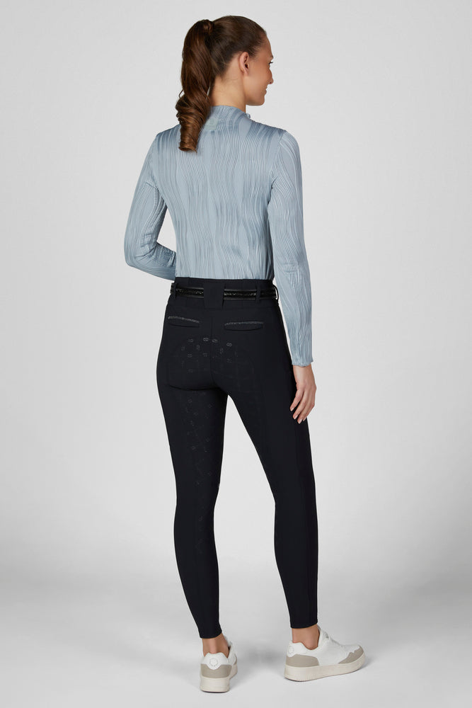 Full body back view of a female model wearing the Dusty Blue Pikeur Long Sleeve Waveline Shirt and navy breeches on a plain background
