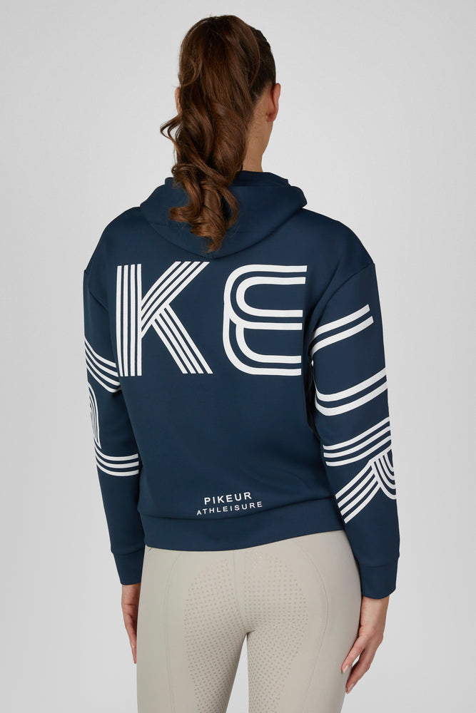 Back view of a female model wearing the Pine Green Pikeur Athleisure Zip Hoody on a plain background