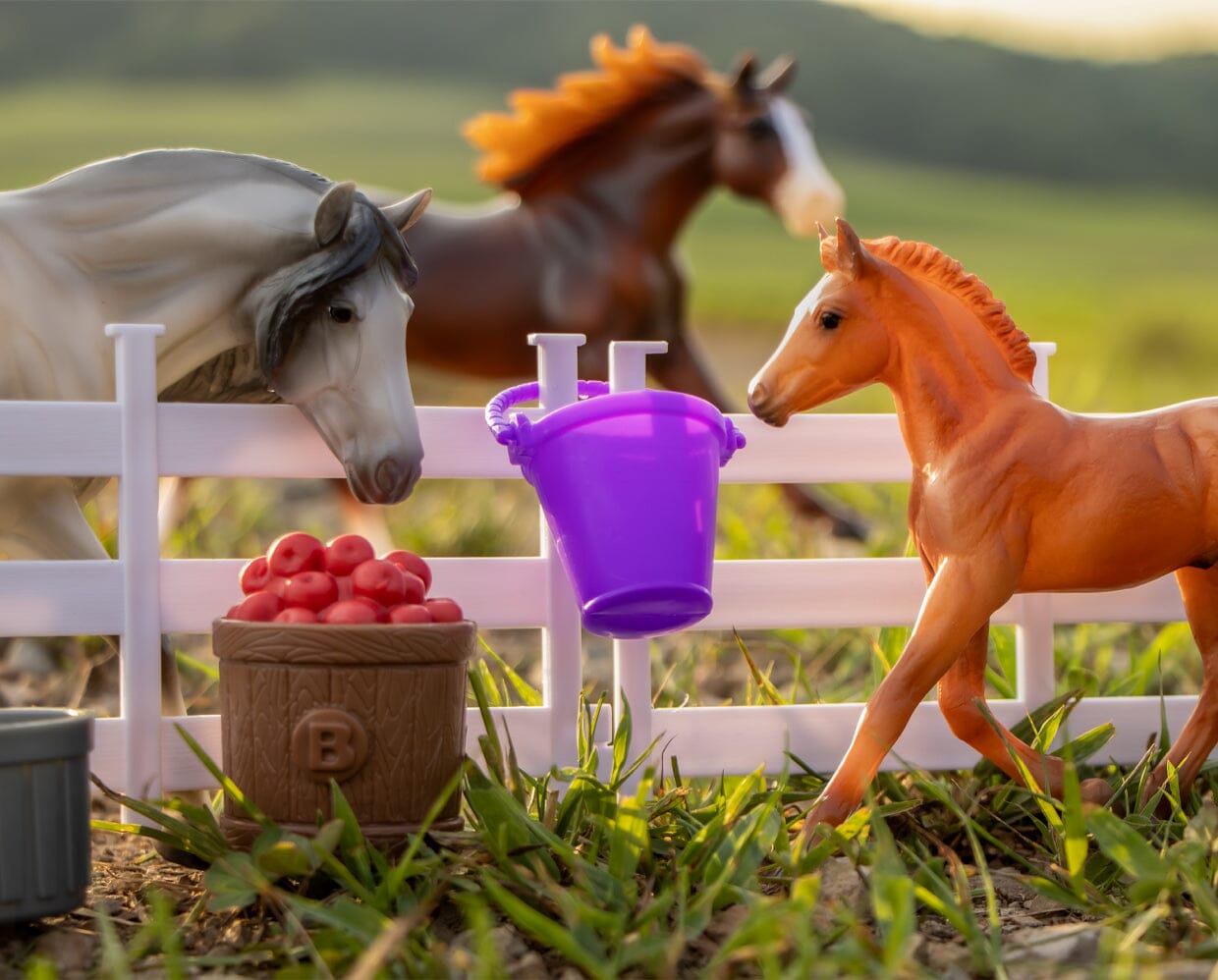 View of the Breyer Playful Pony Family staged outside with accessories