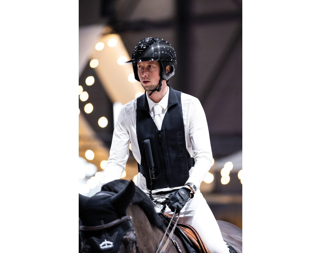 Front view of a male model wearing the Black Freejump Plume Airvest while riding a horse