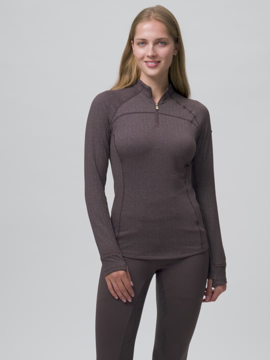 Video of a female model posing while wearing the Cocoa LeMieux Heritage Herringbone Base Layer on a plain background