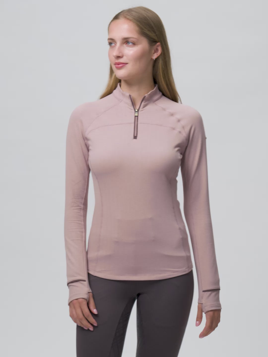 Video of a female model posing while wearing the Wild Rose LeMieux Heritage Herringbone Base Layer on a plain background