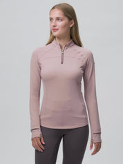 Video of a female model posing while wearing the Wild Rose LeMieux Heritage Herringbone Base Layer on a plain background