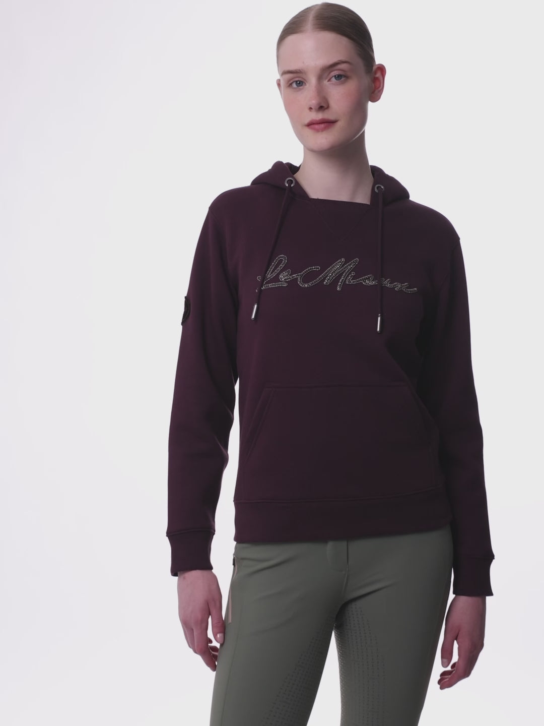 Video of a female model posing while wearing the Damson LeMieux Elspeth Hoodie on a plain background
