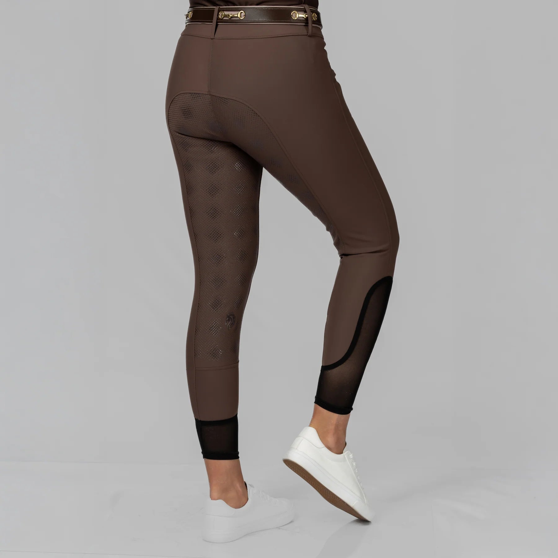 Angled back view of a model wearing the Dark Brown Equinavia Maud Tech Full Seat Breeches on a plain background