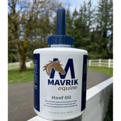 Front view of a 32 oz bottle of Mavrik Hoof Oil with  trees, a white fence, and a road in the background