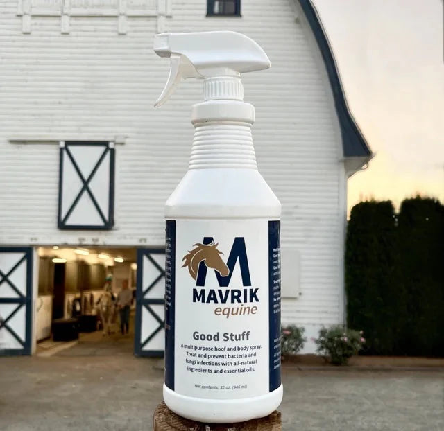 Front view of a 32 oz bottle of Mavrik Good Stuff Multipurpose Spray with a white barn in the background