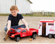 View of a young male model playing with the Breyer Traditional Series "Dually" Truck, Breyer Traditional Series Two-Horse Trailer, and accessories
