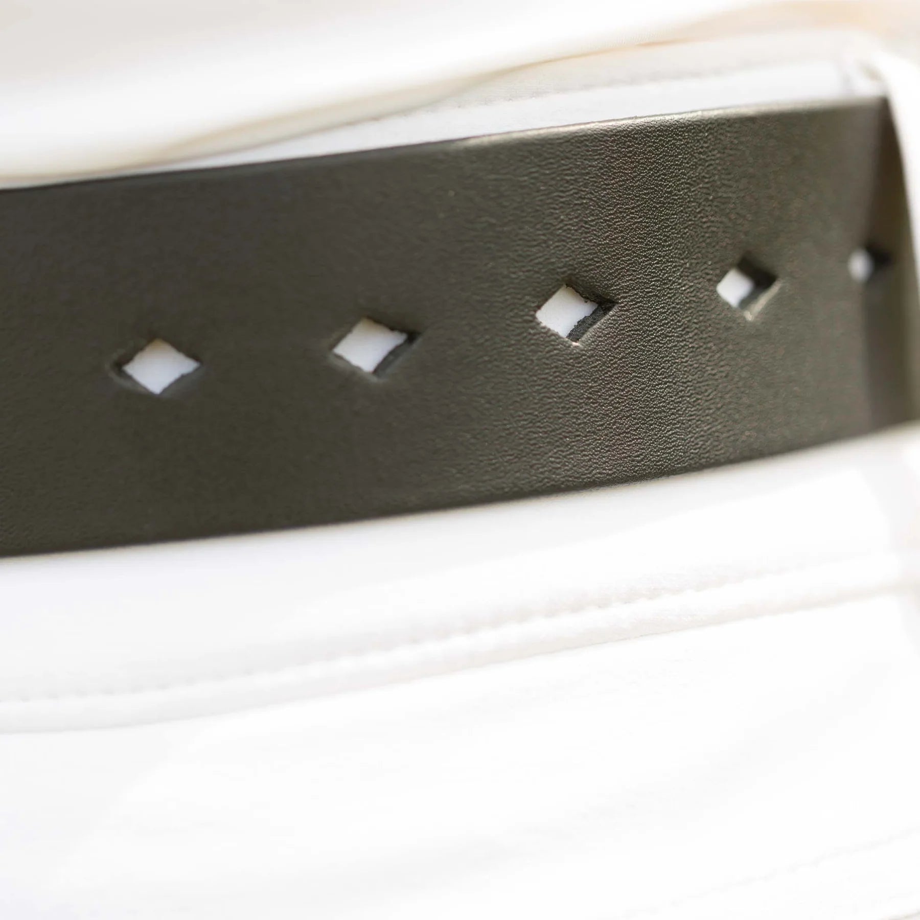 Angled back closeup view of a model wearing the the Equinavia Milli Diamonds Leather Belt showing the diamond-shaped notches