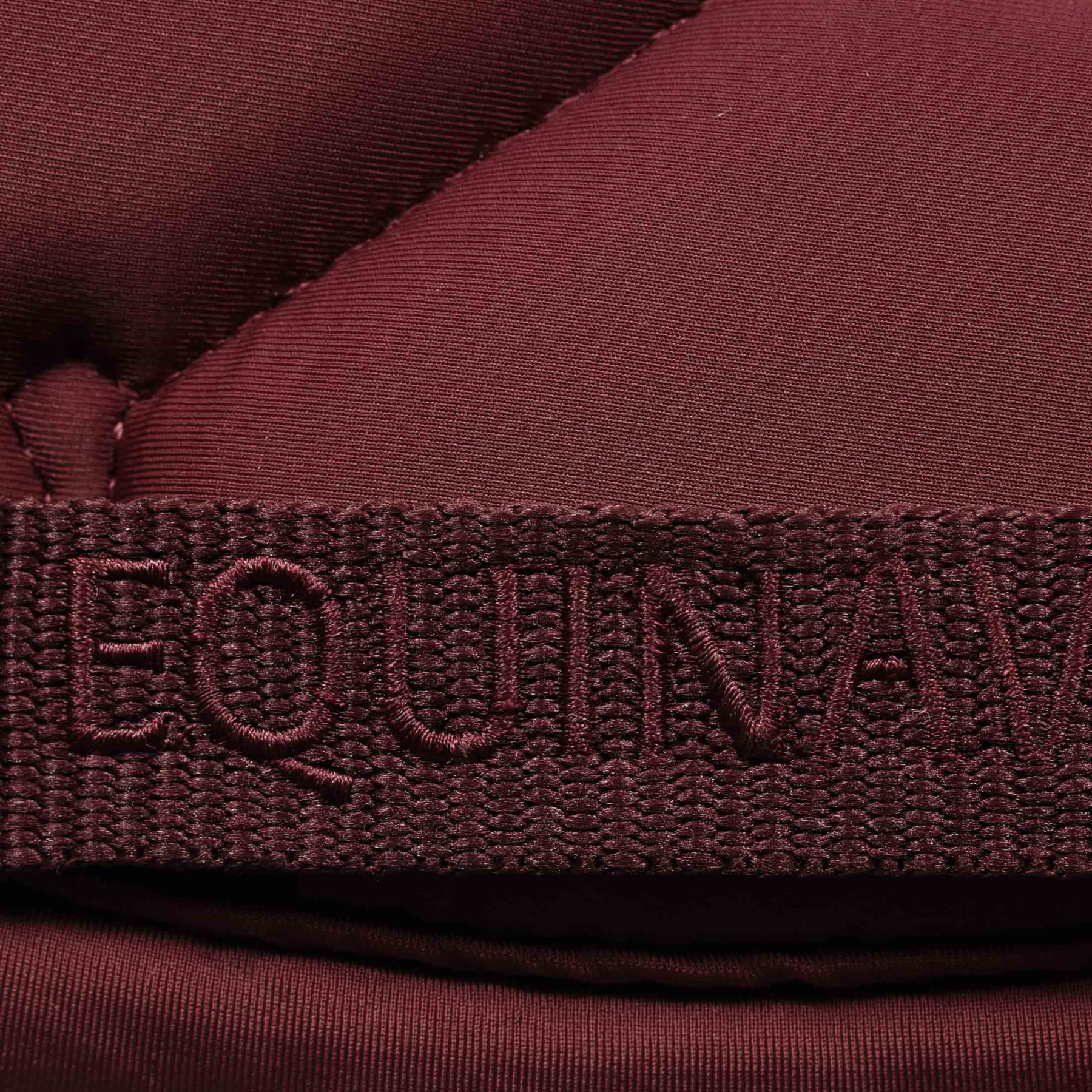 Close-up view of the girth keeper on the Burgundy Equinavia Bergen Crystal All Purpose Pad