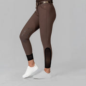 Side view of a model wearing the Dark Brown Equinavia Maud Tech Knee Patch Breeches on a plain background