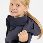 Side view of a young model wearing the Seaborne Navy Horze Paloma Kids Insulated Long Coat on a plain background showing the detachable hood
