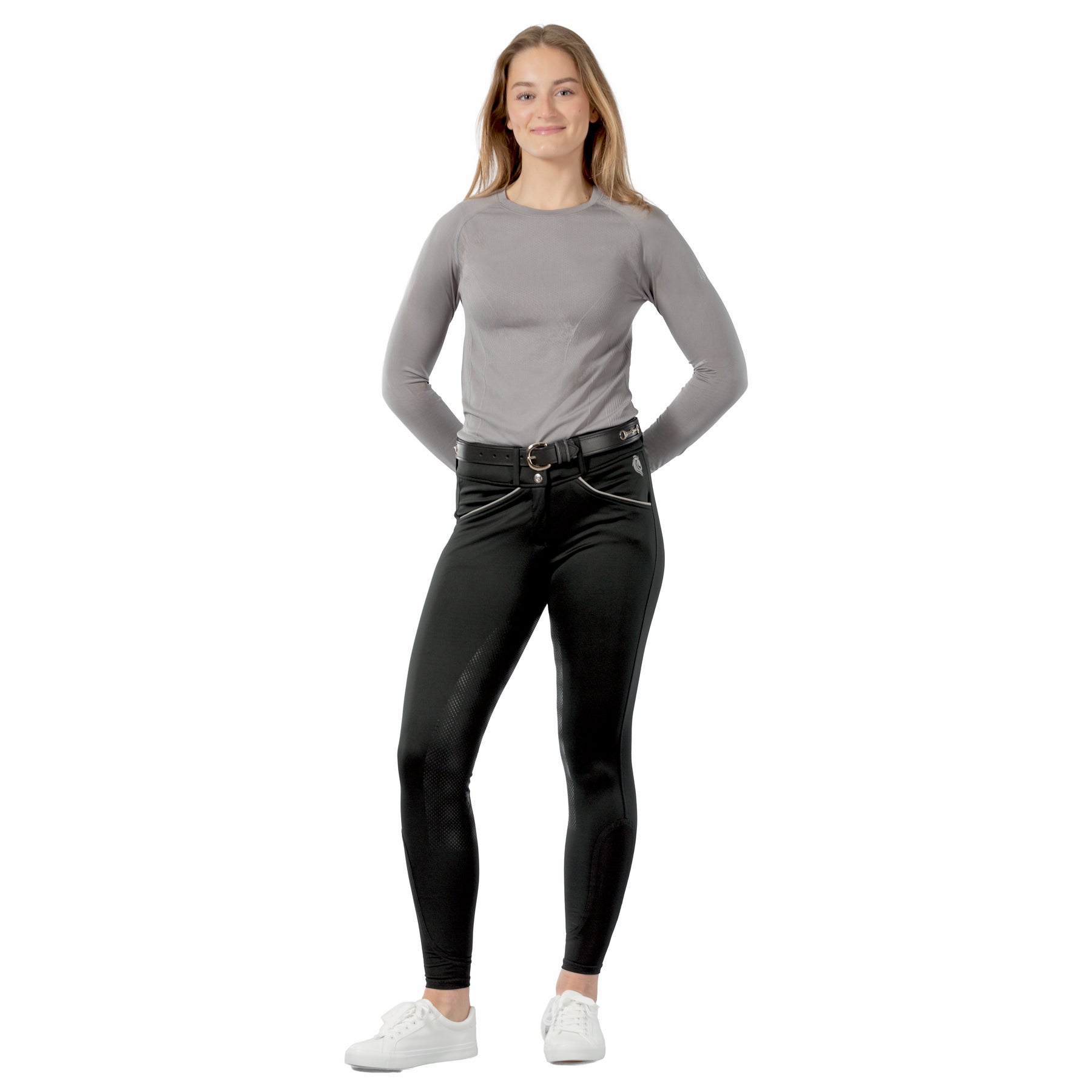 Full body front view of a female model wearing the Black Equinavia Astrid Winter Full Seat Breeches and gray top on a white background