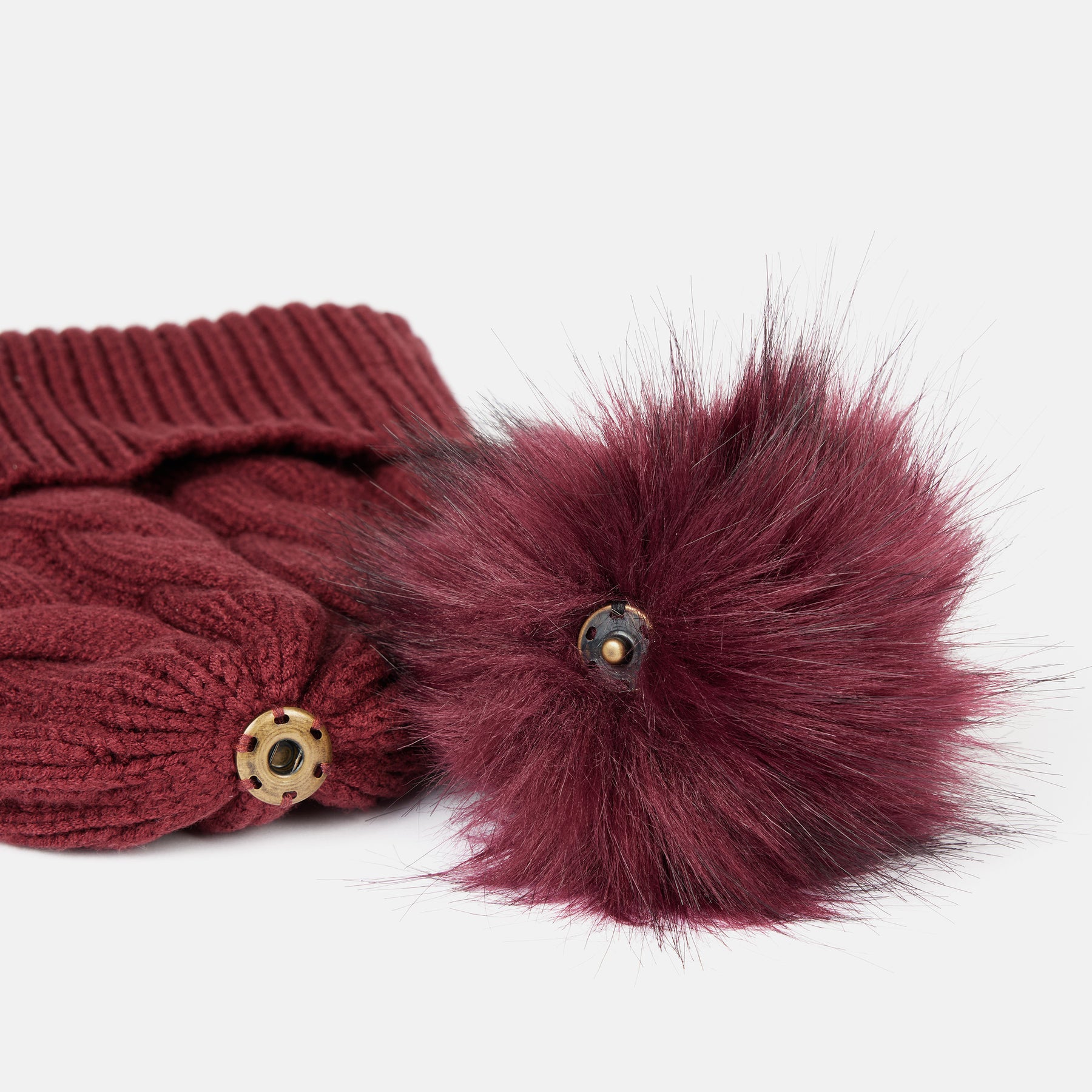 View of the removable pom on the Spiced Apple Horze Anni Knitted Hat on a white background