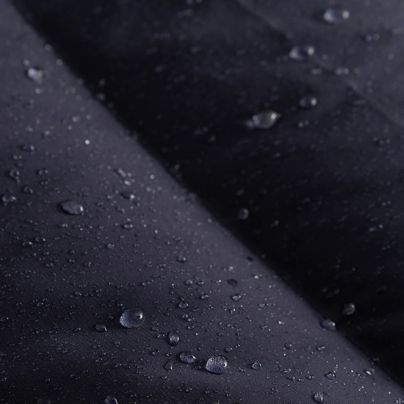 Closeup view of the Seaborne Navy Horze Paloma Kids Insulated Long Coat showing the waterproof fabric