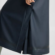 Closeup view of a model wearing the Navy Horze Hazel Womens Long Raincoat on a plain background showing the slits with press buttons